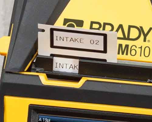 Čerstvě vytištěné etikety vycházející z tiskárny M610. 