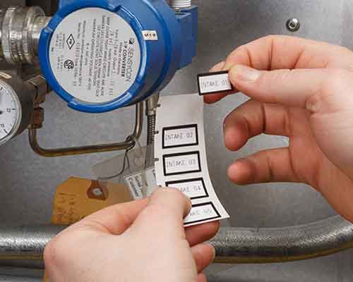 Osoba aplikující etikety vytištěné na tiskárně M610.